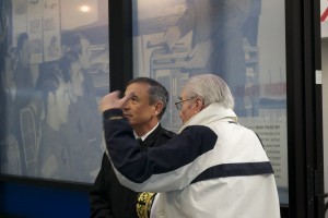 Captain Ted Bronson, USN (Ret.) shows the wall of plaques and squadron memorabilia to Admiral Harris.