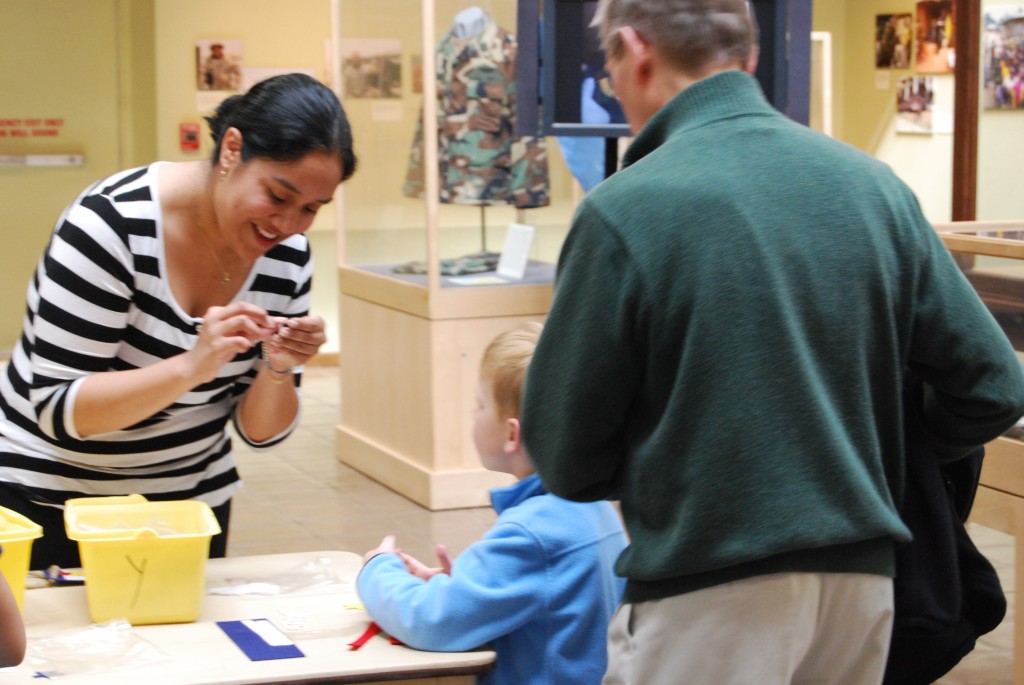NMUSN Curatorial Intern works with a visitor at "Take Your Child to Work" Day.