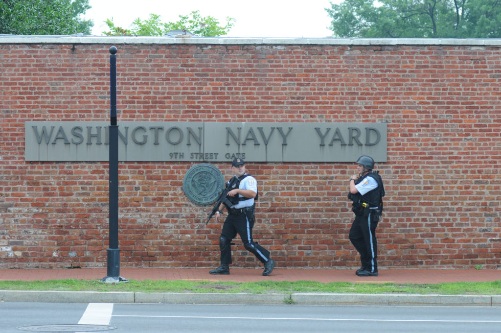150702-N-ED767-103 WASHINGTON (July 2, 2015) Police officers walk past the Washington Navy Yard on M Street in response to a possible active shooter at the Navy Yard. (Oscar Sosa)